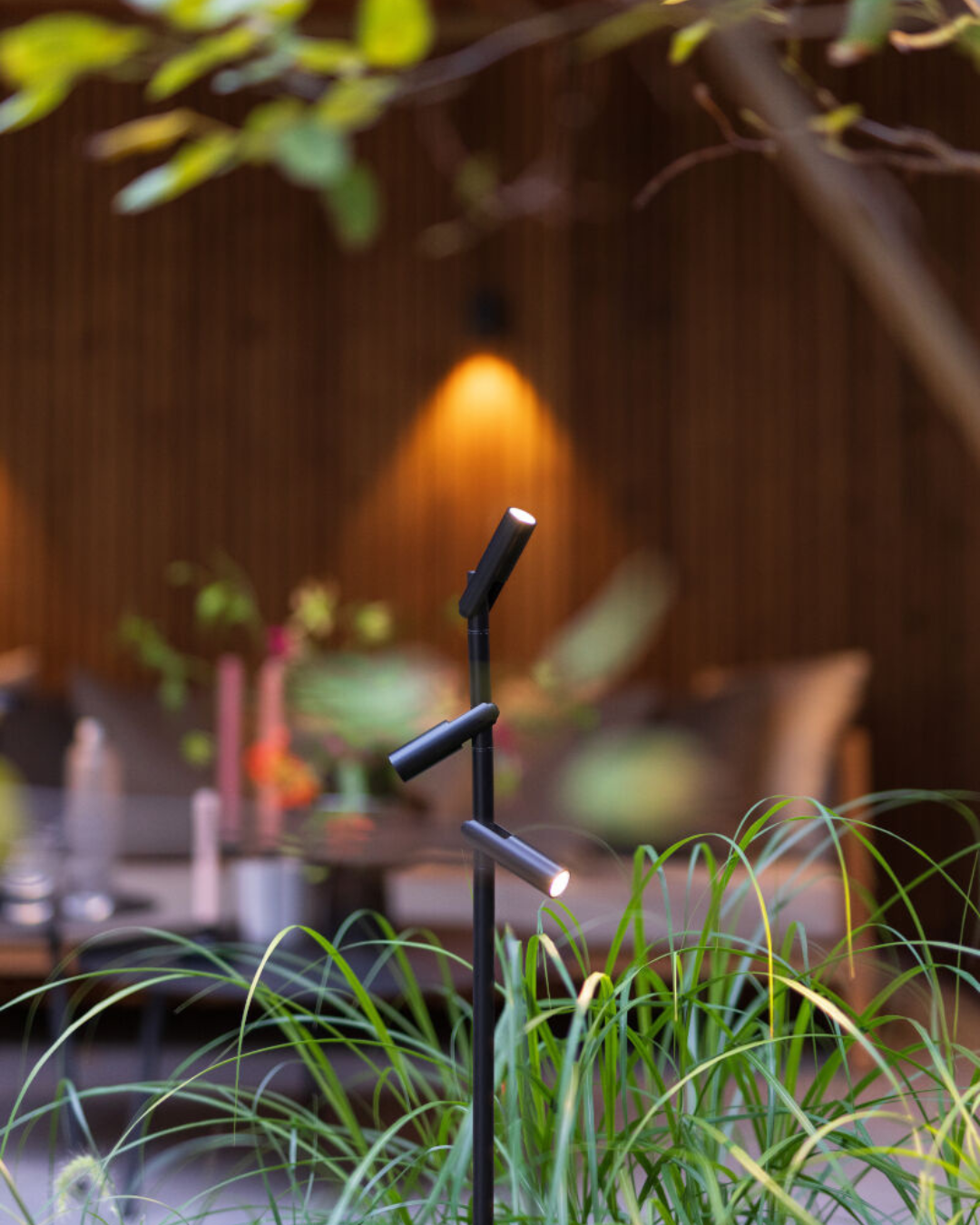 in-lite outdoor lighting stand in garden grasses and on a garden wall