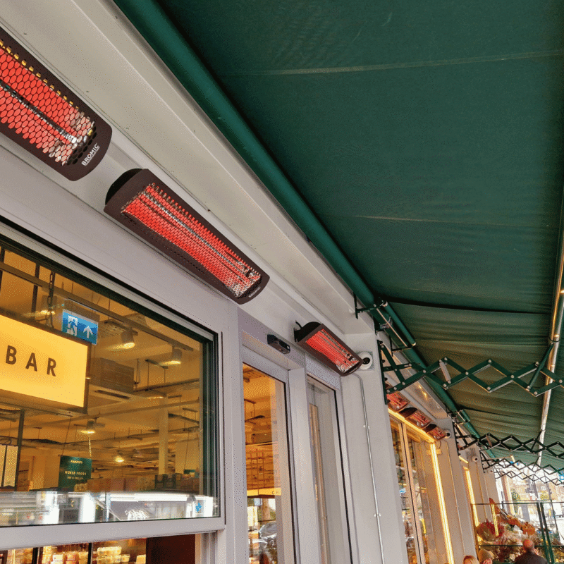 outdoor seating area outside a cafe bar, featuring Bromic wall mounted heaters.